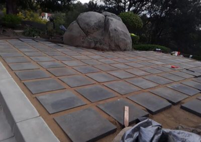 a stone patio with a large rock