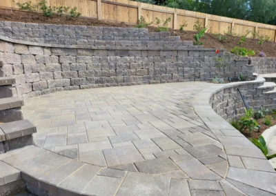 a stone patio with a retaining wall